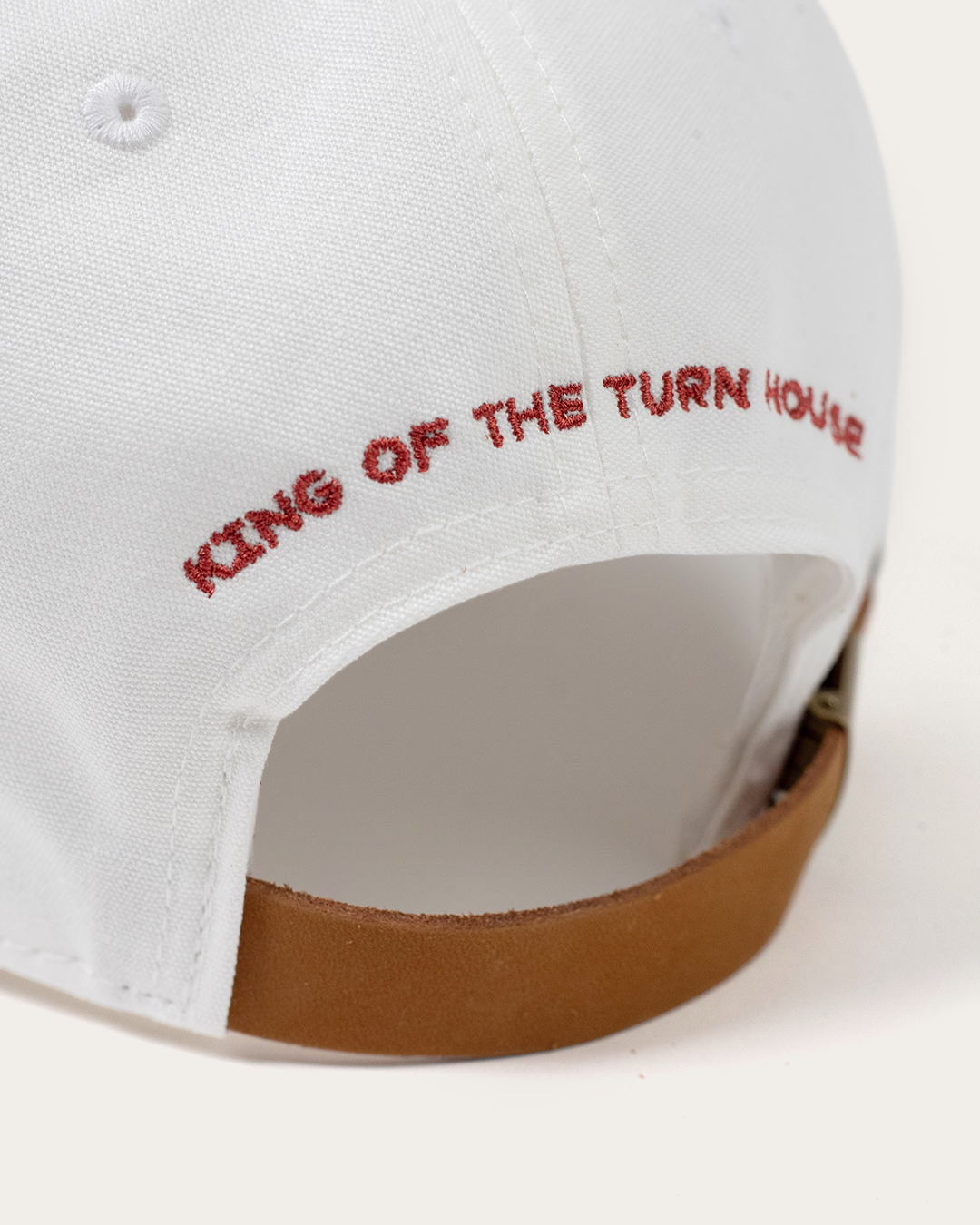 Close-up of the back of the white dad hat embroidered with 'King of the Turn House'
