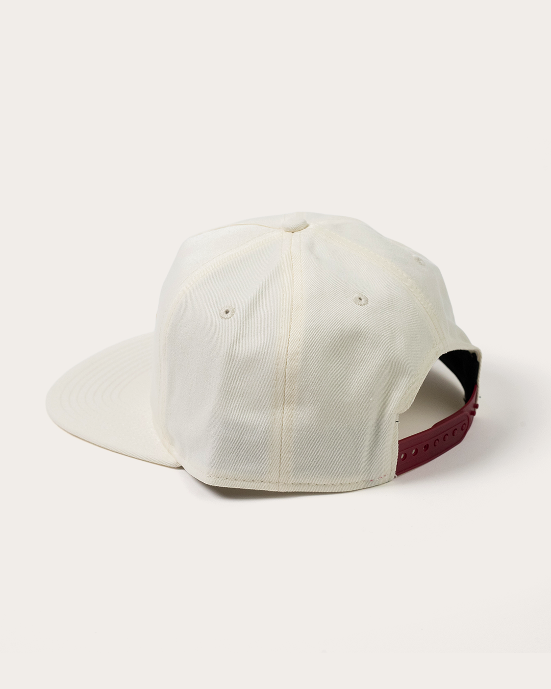 Back view of the cream Gleezy snapback hat showing the adjustable strap